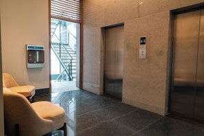 A modern elevator, a water dispenser, and a staircase leading to an upper floor. - Roma Residence Luxury Suites  (Ciudad de México)