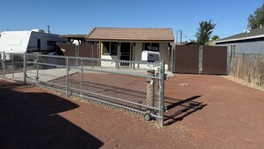 A fenced outdoor area with a building, a mailbox, and a trailer. - Charming 2 BR Little Oasis, with  pool, near Colorado River, SNOWBIRD FRIENLDY (Bullhead City)