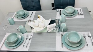 A dining table set with multiple plates, bowls, and cutlery, centered with a decorative item. - Medellín 210  (Ciudad de México)