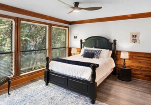 A bedroom with a large bed, a ceiling fan, and a window with blinds. - Lily Pad Lake House @ Lake Fork (Yantis)