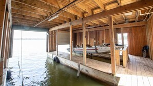 Ein Bootshaus aus Holz mit einem Steg, der sich ins Wasser erstreckt.