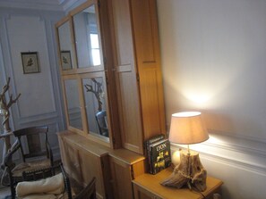 A room with a wooden cabinet, a lamp, a chair, and a bookshelf with books. - Sofa bed near Parc de la tête d'or (Lyon)