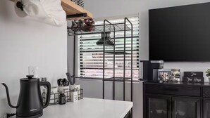 A modern kitchen with a kettle, utensil holder, and a TV. - Old Town Cottonwood-Walk to Shops & Dining (Cottonwood)