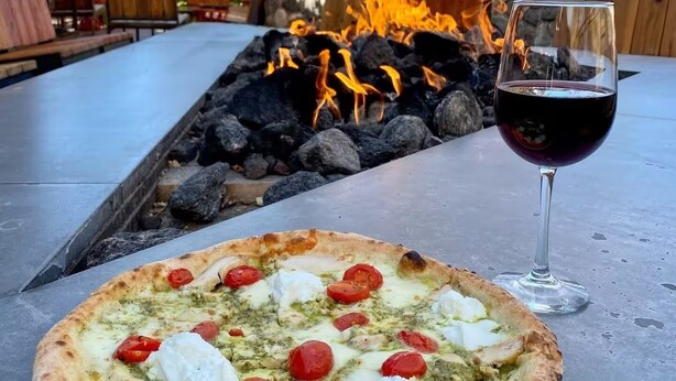 A pizza with toppings and a glass of red wine on an outdoor table. - Old Town Cottonwood-Walk to Shops & Dining (Cottonwood)