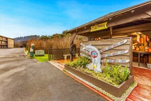 A wooden building with a sign reading 'Clam Shack' and a wooden sculpture of a fish with skis.