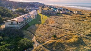 Oversigtsbillede af et kystnære boligområde med huse, en vej og en strand.