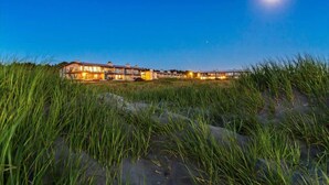 A beachfront property with multiple buildings, a clear sky, and a visible moon. - Hi-Tide Resort, Top Floor, Queen Bed, Unit 29 (Moclips)
