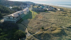 Vista aerea di una zona residenziale costiera con case, una spiaggia e una strada.