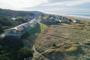 Vista aérea de una zona residencial costera con casas, una playa y una carretera.