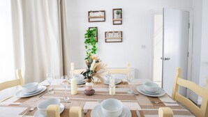 A dining room with a table set for six, including plates, glasses, and cutlery. - Stylish 3BR Home Near NEC & Airport | Sleeps 6-7 (Solihull)