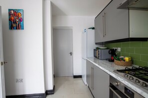 Una cocina equipada con refrigerador, microondas y estufa a gas.
