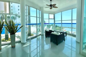 A spacious room with large windows, a ceiling fan, and a view of the sea. - 23rd Floor - Beachfront - Pool & Sauna (Cartagena de Indias)