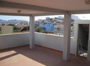 A balcony with a view of a cityscape and mountains.