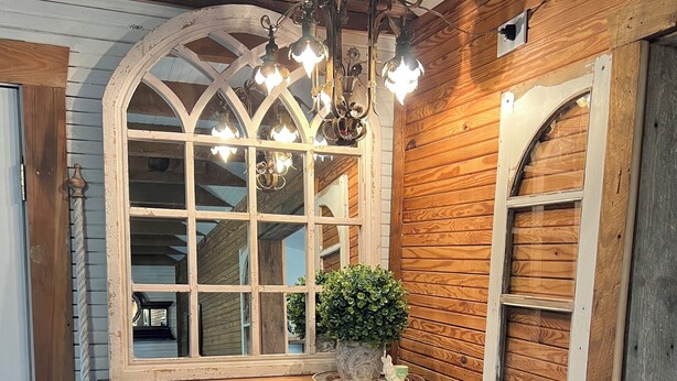 A wooden dresser with drawers, a mirror with a decorative frame, and a chandelier. - Cozy 1-bedroom cottage in lovely Rocky Mount with AC (Rocky Mount)