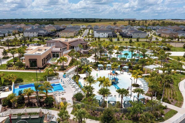 A residential area with houses, a swimming pool, and a park with palm trees. - Family Friendly Stay in Prime Location (Kissimmee)