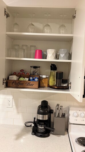 Eine Küche mit einer Kaffeebar, einer Kaffeemaschine und verschiedenen Küchenutensilien.