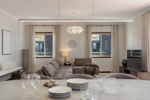 Ein modernes Wohnzimmer mit einer Couch, einem Esstisch und einem Fernseher.
