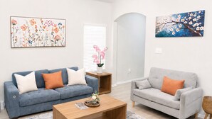 A living room with two sofas, a coffee table, and artwork on the walls. - [GS] 3BR+3BR I 2 Kitchens I Two Adjacent Townhomes I Brand New & Family-Friendly (San Antonio)
