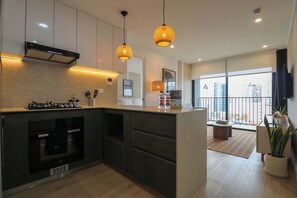 A modern kitchen with a built-in oven, a gas stove, and hanging pendant lights. - w* | Upscale 2BR w/ Balcony & View in Miraflores (Miraflores)