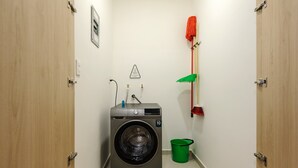 A compact laundry room with a washing machine, a mop, and a bucket. - w* | Upscale Loft w/ Balcony in Roma Norte (Ciudad de México)