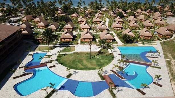 A resort with multiple bungalow-style accommodations, a central swimming pool, and a view of the ocean. - Eco Resort Apartment - Carneiros Beach (Tamandaré)