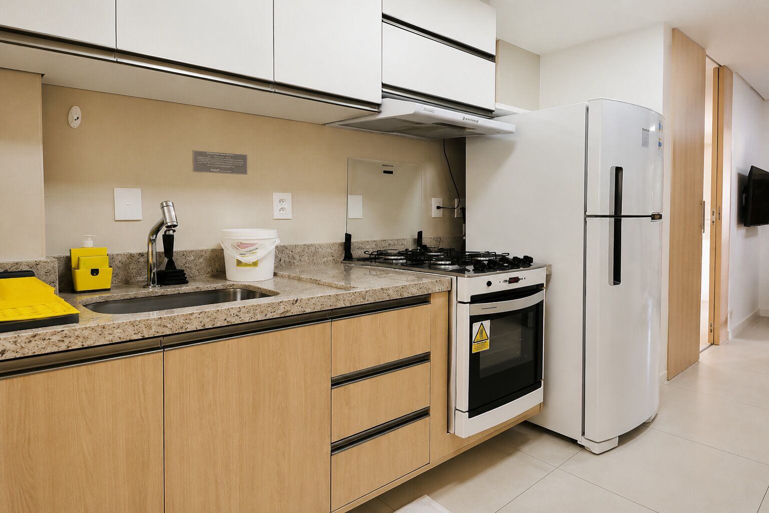 A kitchen with a sink, stove, oven, and refrigerator.