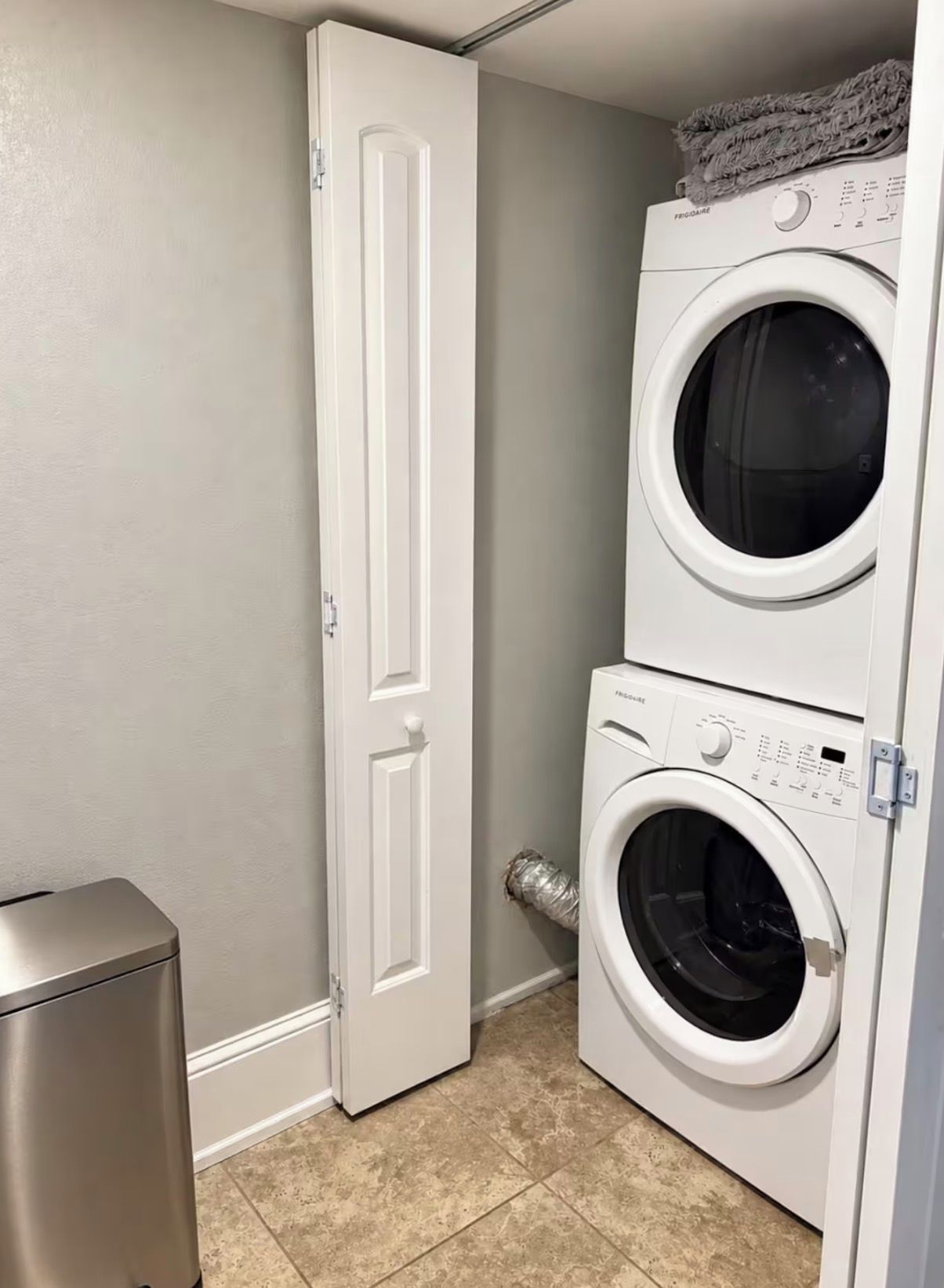 A laundry room with a door, a washing machine, and a dryer.
