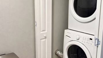A laundry room with a door, a washing machine, and a dryer.