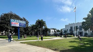 Ein sonniger Tag an der Venice High School mit blauem Himmel, einem großen Schild und einer Fahnenstange.
