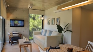 Una sala de estar moderna con sofá, sillas, una mesita de centro y obras de arte en las paredes.