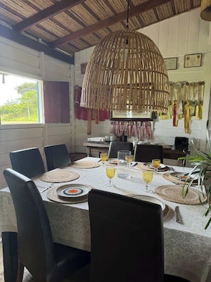 Comedor con una mesa grande preparada para seis personas, rodeada de sillas.