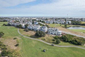 A residential area with houses, a golf course, and a body of water. - 5590 - Sand Hills South, Soundfront 6BR, 4BA Nags Head retreat for 12. (Nags Head)