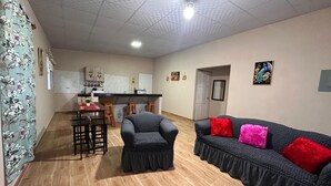 Una sala de estar con sofá, sillón y mesa de comedor.