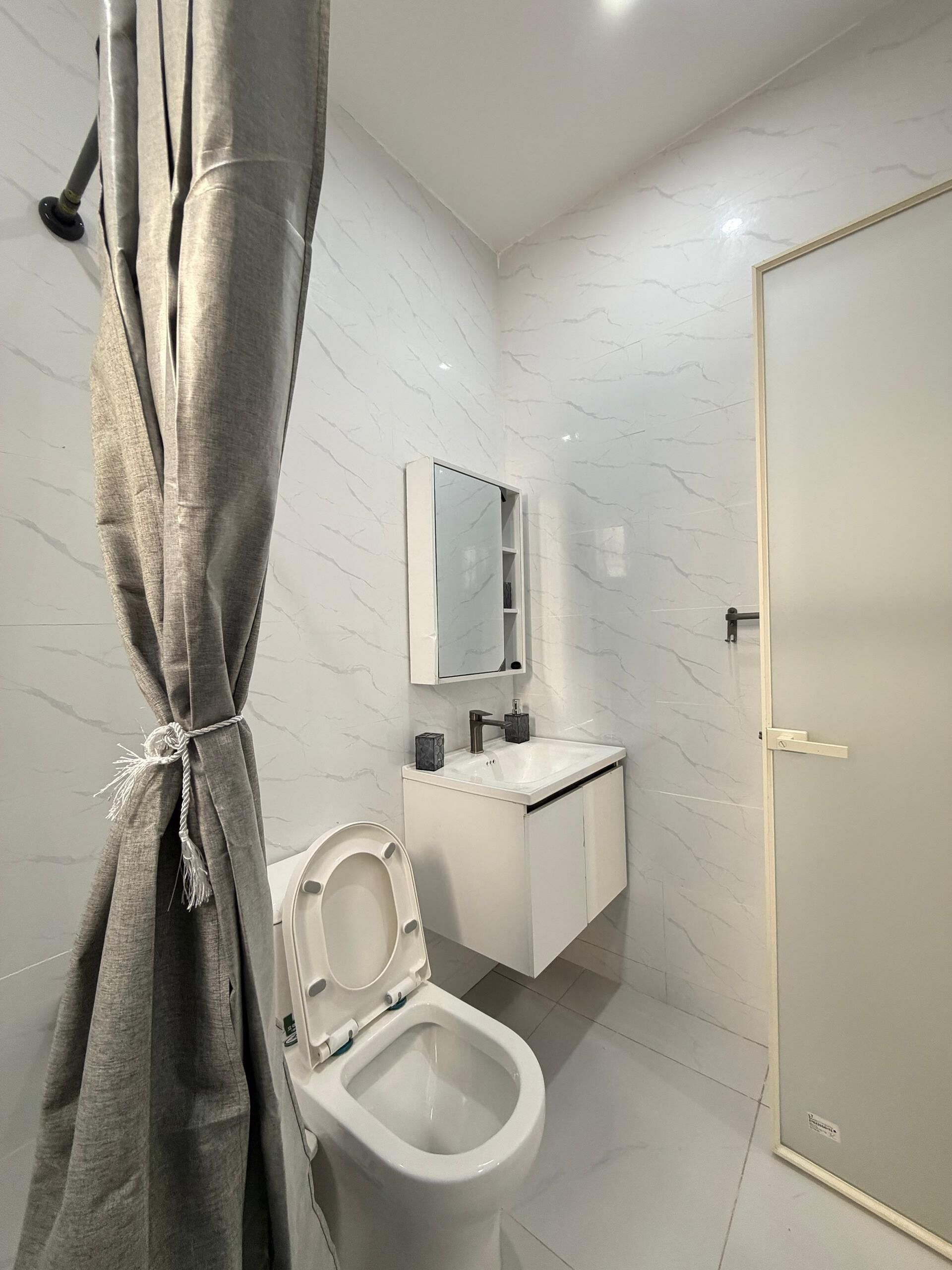 Une salle de bain moderne avec des toilettes, un lavabo et un miroir.