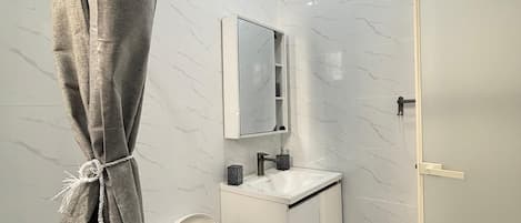 Une salle de bain moderne avec des toilettes, un lavabo et un miroir.