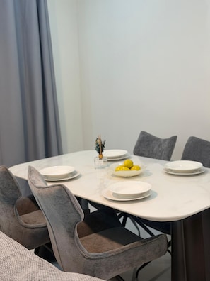 A dining table with chairs, plates, and a bowl of lemons. - Couramina (Dakar)