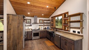 A kitchen with wooden cabinets, a stainless steel range, and a large window.