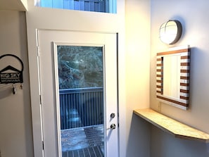 A door with a glass panel, a metal handle, and a keyring with 'BIG SKY MONTANA' on it. - Between the Pines | Ski, Hike, Fish, Soak, Repeat (Big Sky)