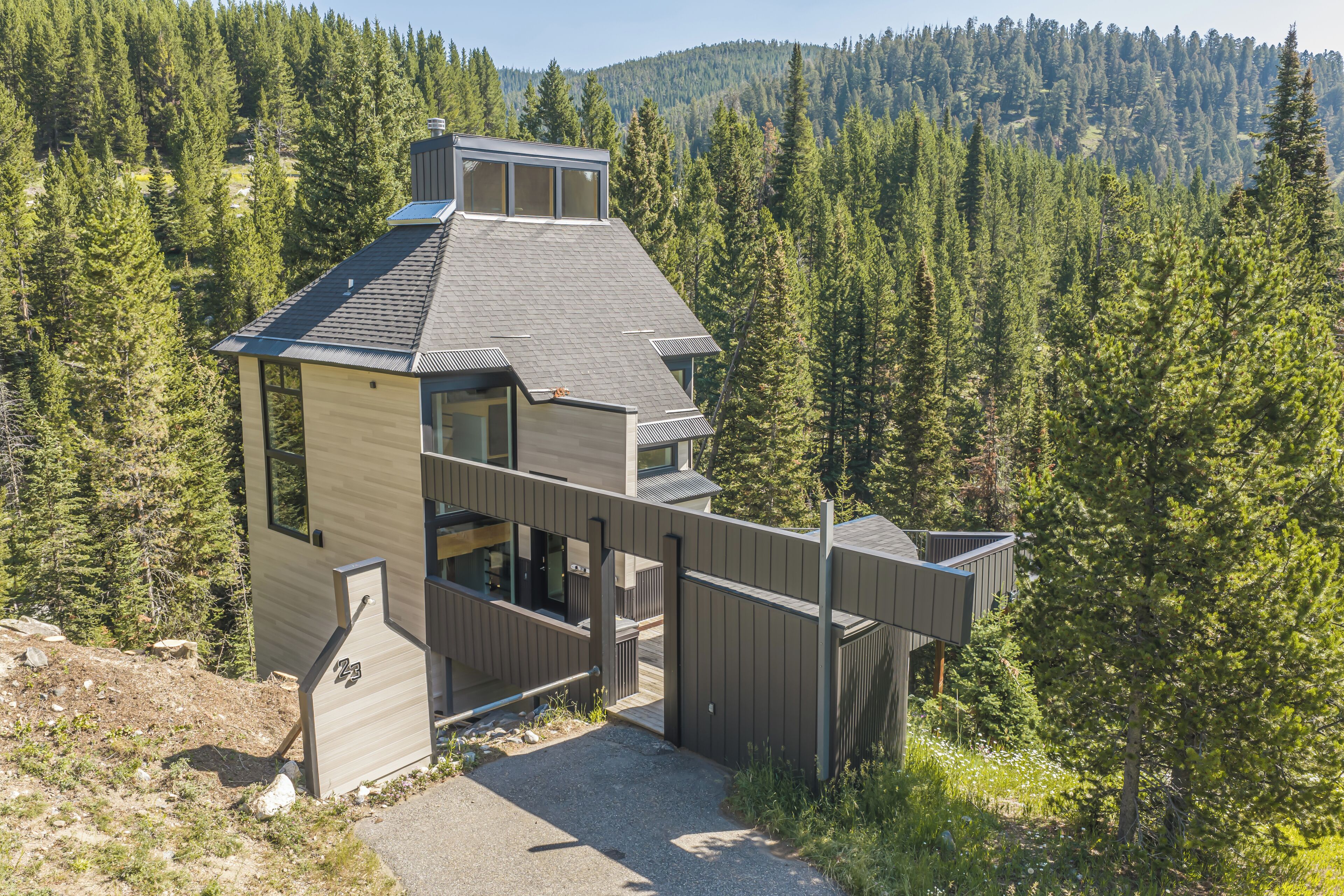 A modern cabin with a sloped roof, large windows, and a deck area.