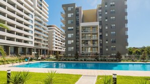 Un moderno condominio con una piscina in primo piano.