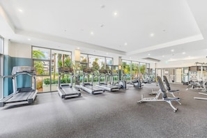 A gym with treadmills, elliptical machines, and weight benches. - A Little Slice of Paradise Pool, Gym+Parking (Macquarie Park)