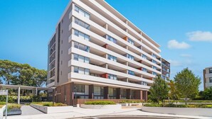 Un edificio a più piani dal design architettonico moderno, caratterizzato da un tetto piatto, ampie finestre e un ingresso a livello strada.
