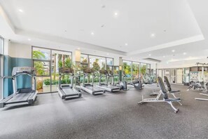 Een fitnessruimte met loopbanden, elliptische trainers en krachtapparaten.