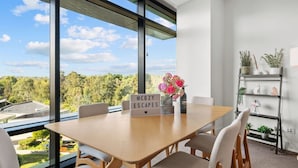Une chambre moderne avec une grande fenêtre, une table en bois et un panneau indiquant « ESCAPADES CONFORTABLES ».