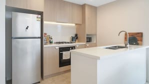 Een moderne keuken met een koelkast, fornuis, oven en spoelbak.
