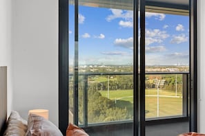 Una habitación con un ventanal que ofrece vistas a un parque y al paisaje urbano.