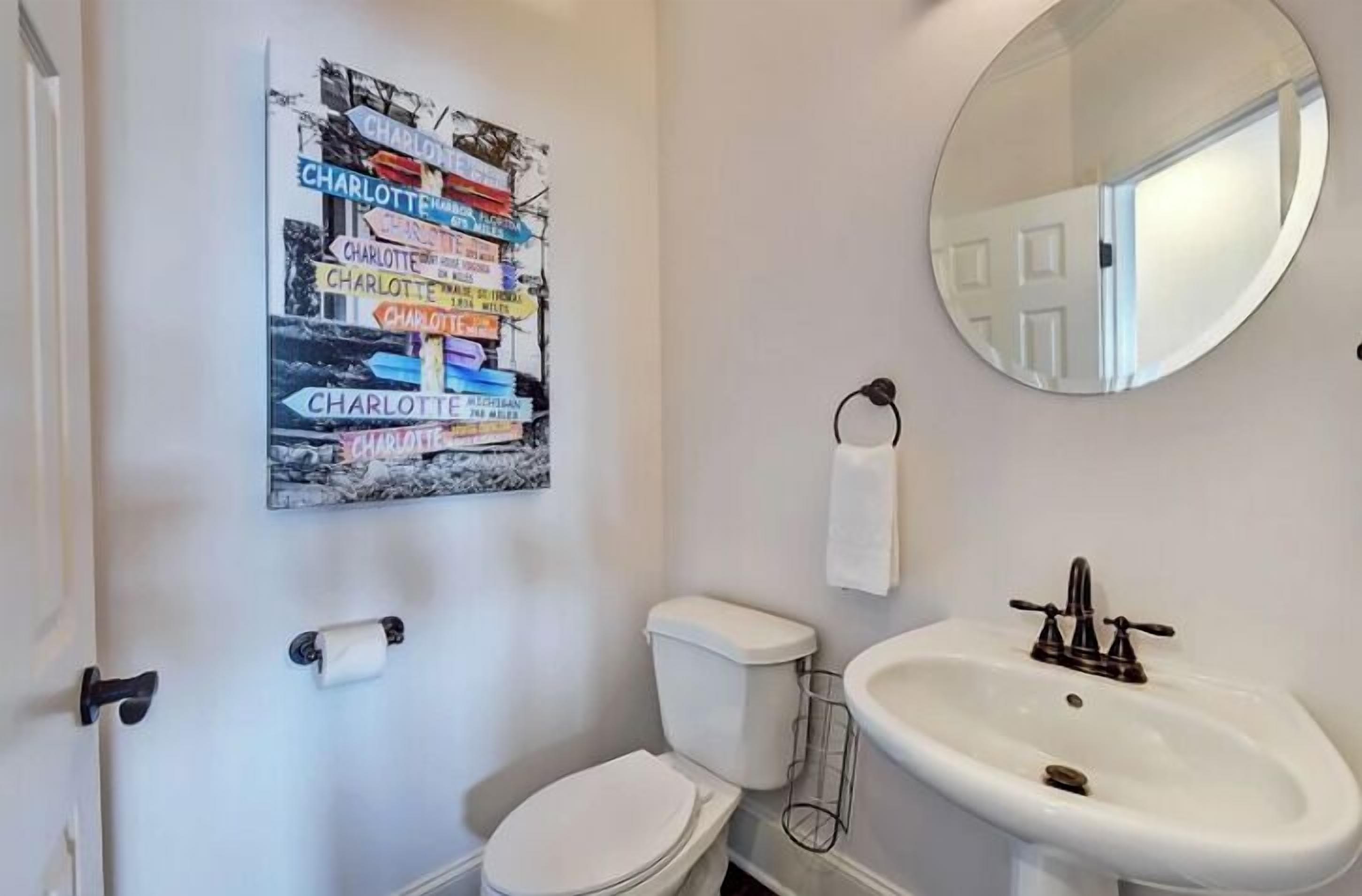 Ein Badezimmer mit Toilette, Waschbecken und einem Spiegel an der Wand.