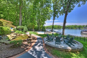 Un patio junto al lago con sillas Adirondack, un pequeño estanque y vistas al lago.