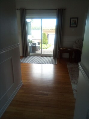 A hallway leading to a sliding glass door with a view of a patio area.