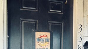 A black door with a sign advertising a 5-cent lunch.